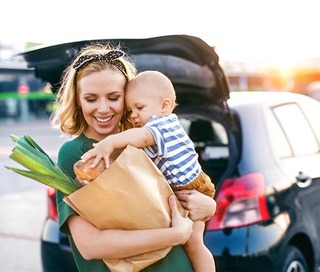 Eine junge Mutter erledigt Einkäufe mit Ihrem Kleinkind