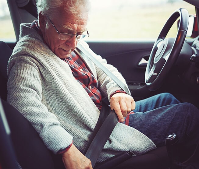 Ein Senior fährt mit seinem Auto los